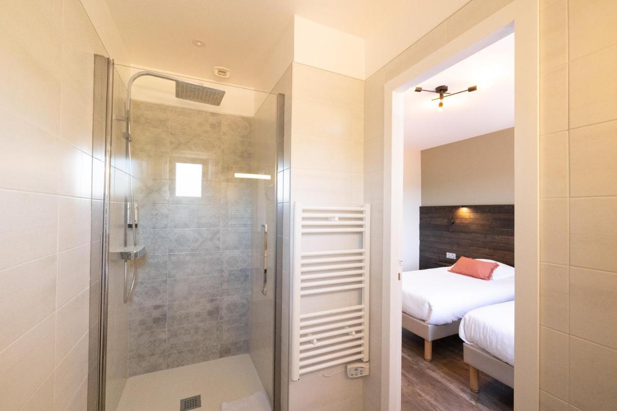 une salle de bains avec douche à l'italienne à côté d'un lit dans l'établissement LOGIS Hôtel St Sylvestre, à Aldudes