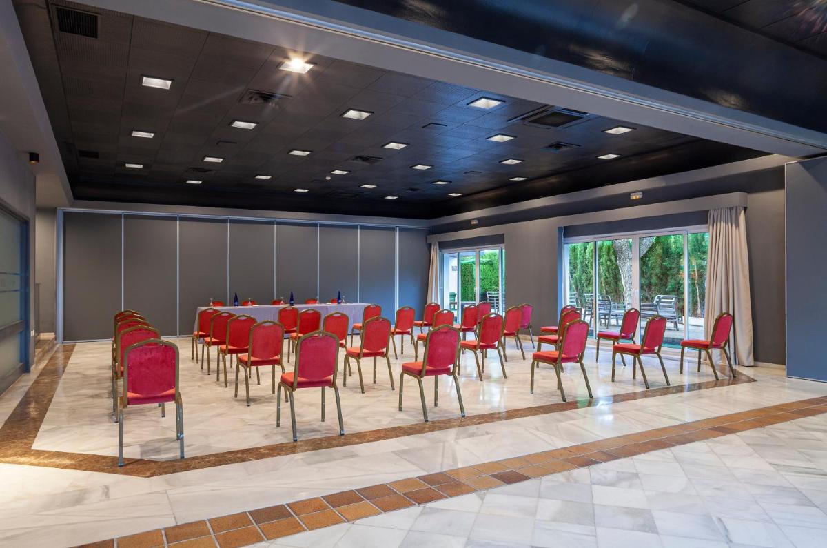 Una sala de conferencias con una mesa y sillas rojas. en Hotel Jerez & Spa, en Jerez de la Frontera 218 fotos más
