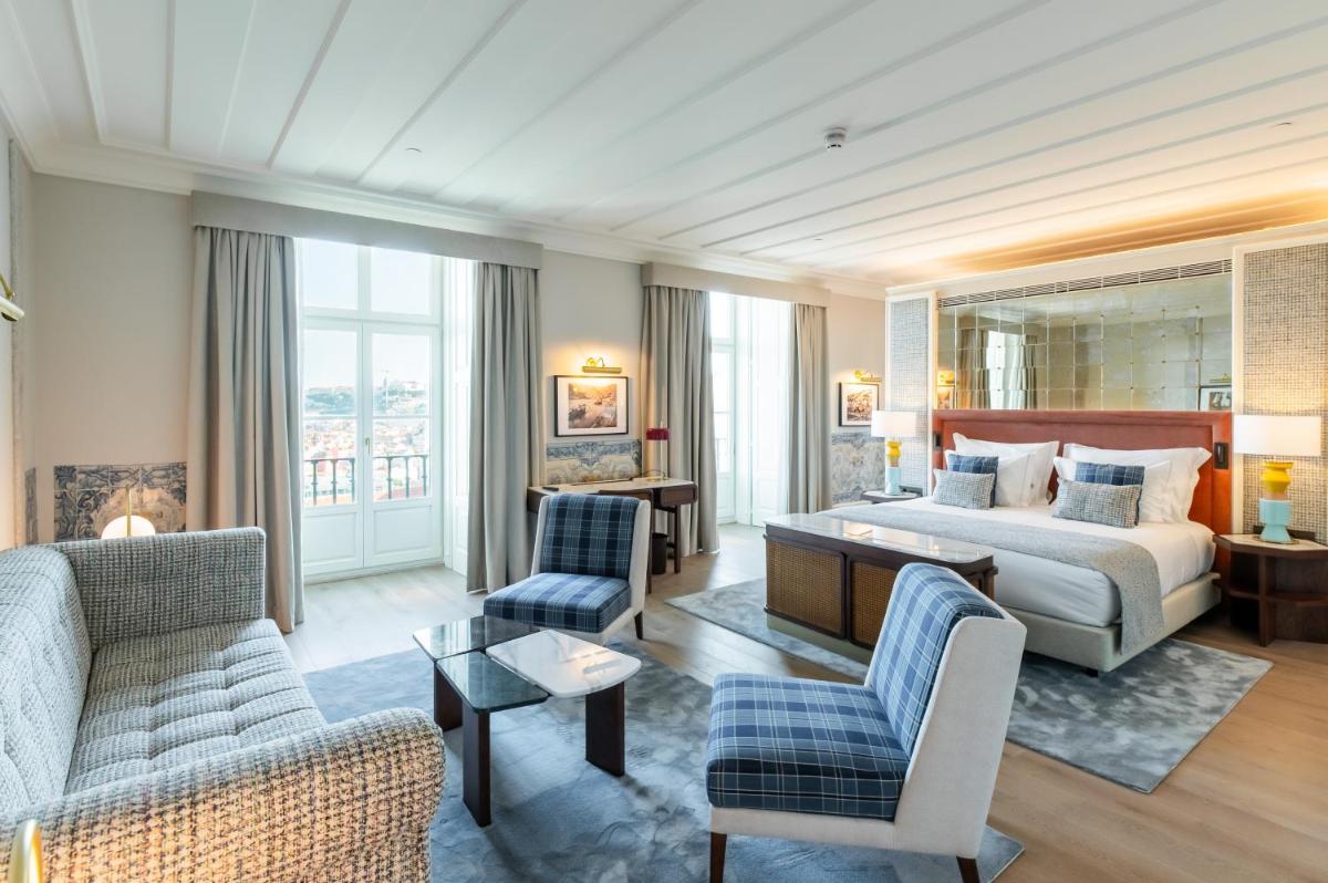 um quarto de hotel com uma cama e uma sala de estar em Palácio Ludovice Wine Experience Hotel em Lisboa um quarto de hotel com uma cama e uma sala de estar em Palácio Ludovice Wine Experience Hotel em Lisboa