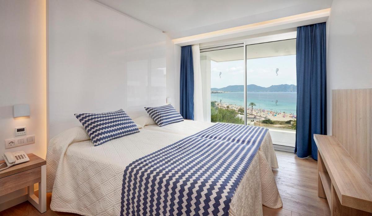 Un dormitorio con una cama con vista al mar. en Hipotels Bahia Cala Millor - Adults Only, en Cala Millor 48 fotos más