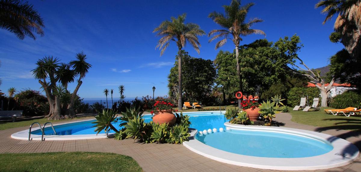 una piscina en un complejo con palmeras en La Palma Jardín Resort, en El Paso