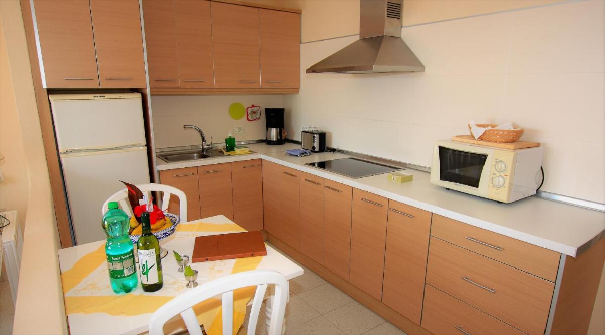 Una pequeña cocina con una mesa y un microondas. en La Palma Jardín Resort, en El Paso