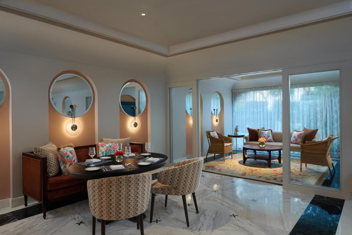 a living room with a table and chairs and a dining room at The Leela Palace Jaipur in Jaipur