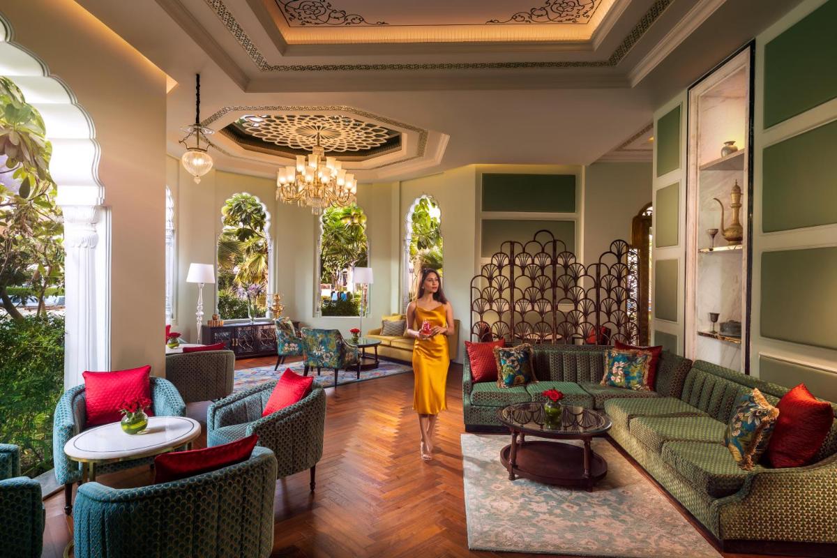 a woman walks through the lobby of a hotel at The Leela Palace Jaipur in Jaipur