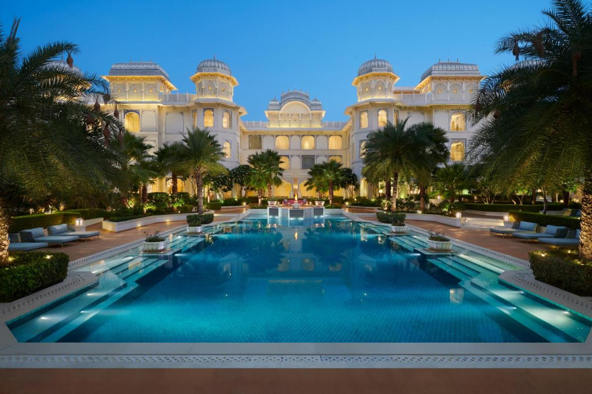 a large swimming pool in front of a building at The Leela Palace Jaipur in Jaipur