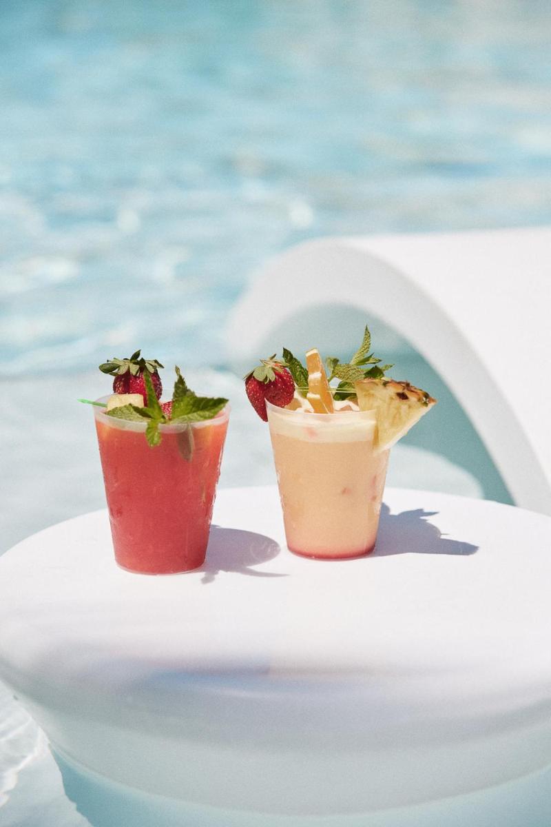 dos cócteles sentados en una mesa junto al agua en Alanda Marbella Hotel & Wellness, en Marbella