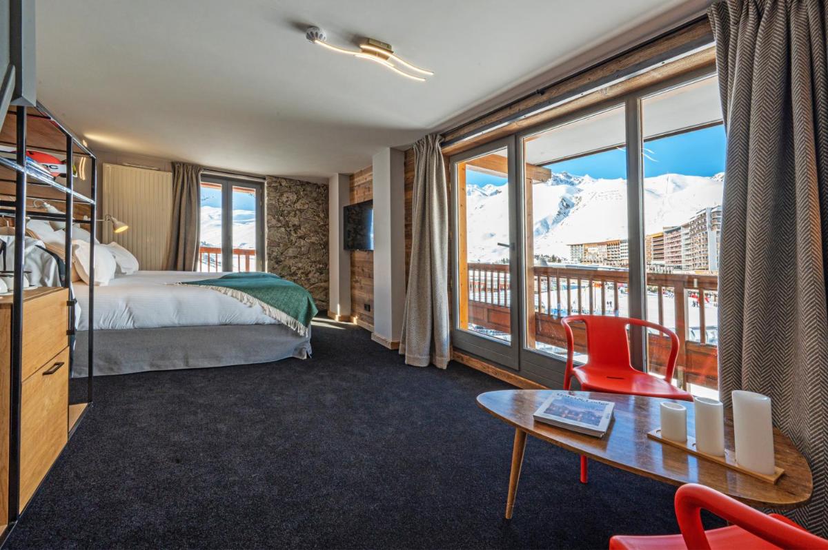Cette chambre d'hôtel dispose d'un lit et d'un balcon avec vue sur les montagnes. dans l'établissement Hôtel Le Levanna by Les Etincelles, à Tignes