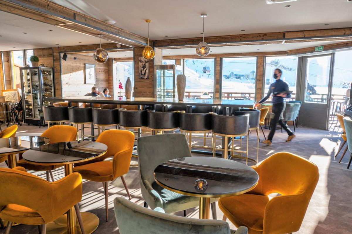 un restaurant avec des tables et des chaises et un bar dans l'établissement Hôtel Le Levanna by Les Etincelles, à Tignes