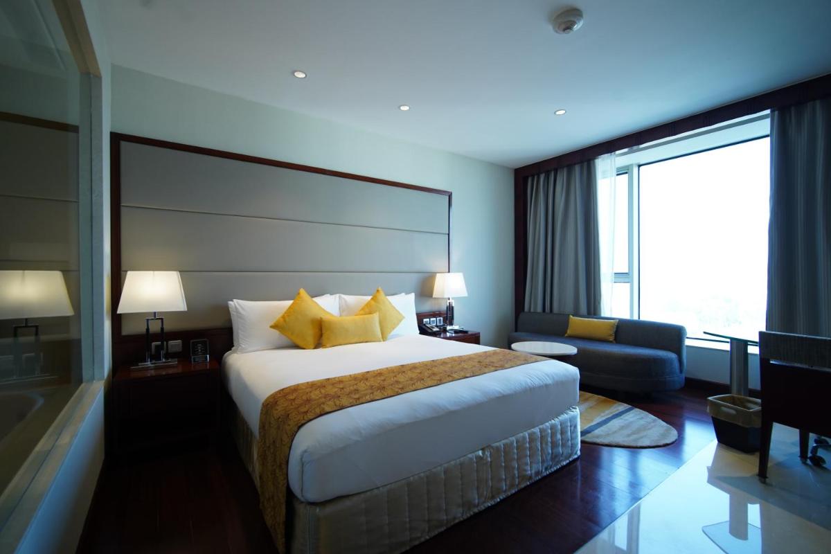 a hotel room with a bed and a large window at Crowne Plaza Kochi by IHG in Cochin
