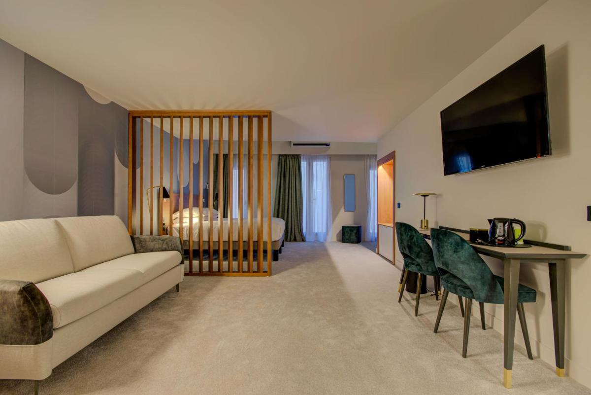 un salon avec un canapé et une table dans l'établissement Alex Hotel & Spa, à Marseille