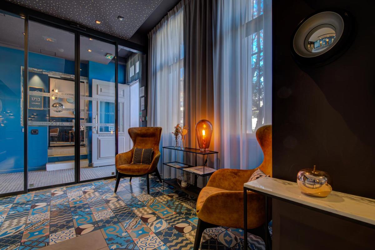 une chambre avec deux chaises, une table et des fenêtres dans l'établissement Alex Hotel & Spa, à Marseille