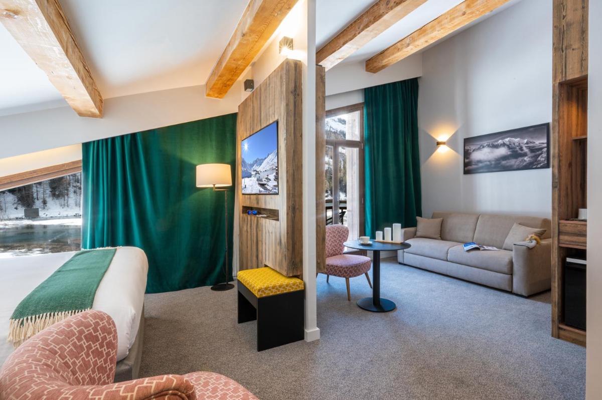 une chambre d'hôtel avec un lit et un canapé dans l'établissement Hotel Tetras Lodge, à Tignes