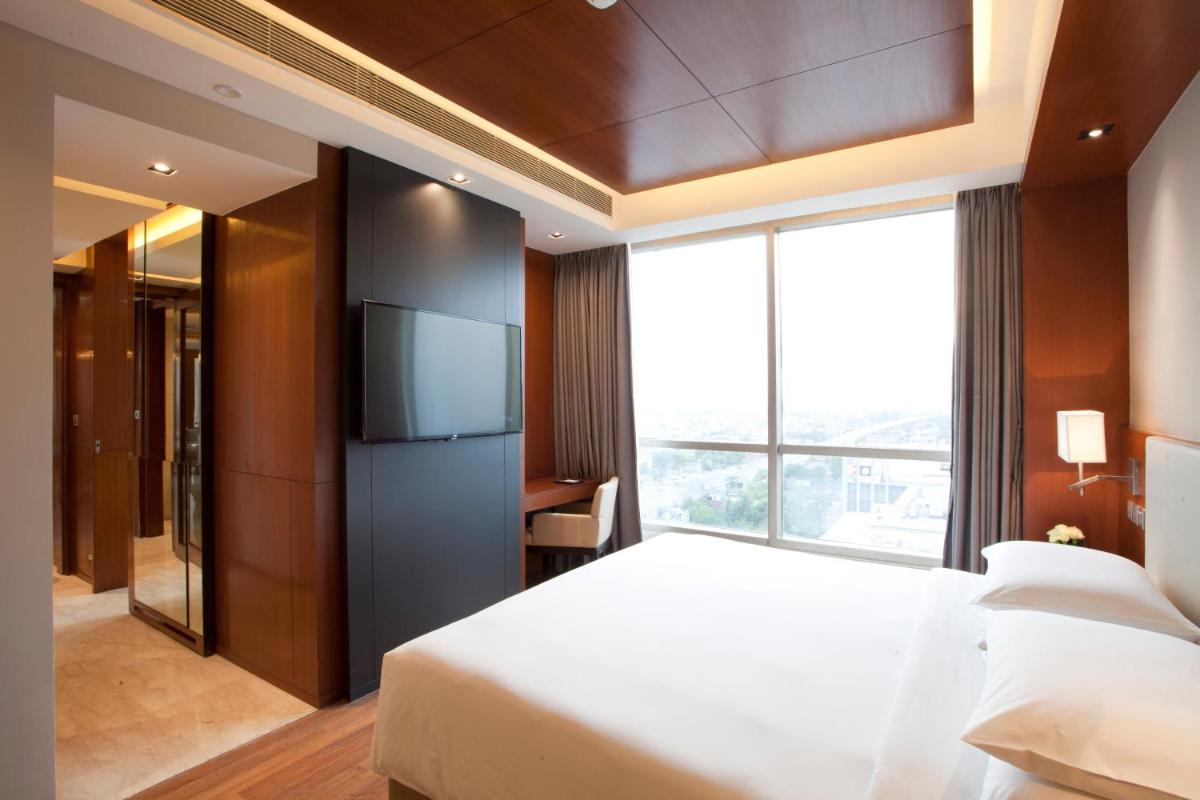 a bedroom with a large bed and a large window at Hyatt Regency Amritsar Hotel & Spa in Amritsar