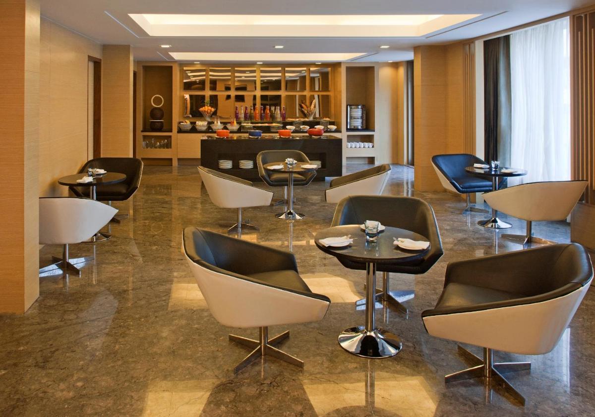 a restaurant with chairs and tables in a room at Radisson Blu Hotel Amritsar in Amritsar