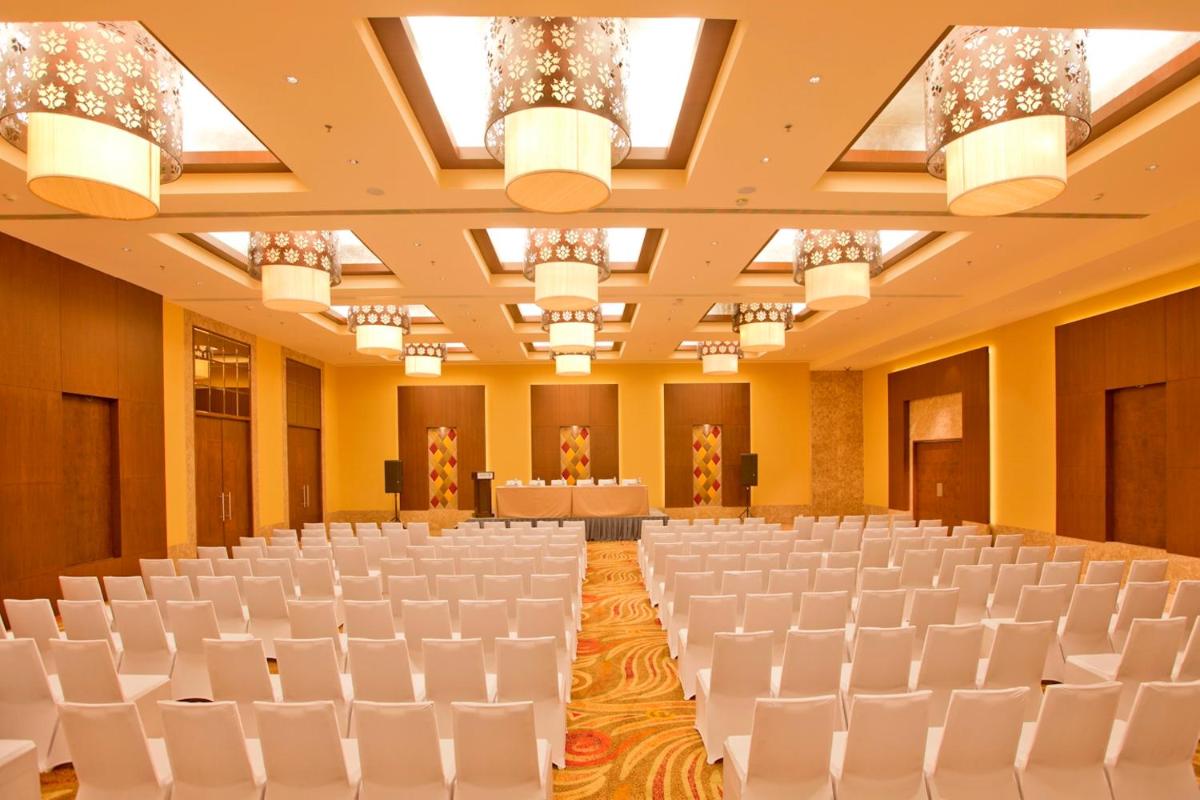 an empty banquet hall with white chairs and lights at Radisson Blu Hotel Chennai City Centre in Chennai an empty banquet hall with white chairs and lights at Radisson Blu Hotel Chennai City Centre in Chennai
