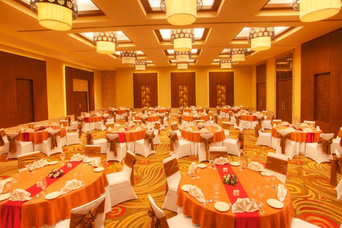 a large banquet hall with tables and white chairs at Radisson Blu Hotel Chennai City Centre in Chennai a large banquet hall with tables and white chairs at Radisson Blu Hotel Chennai City Centre in Chennai