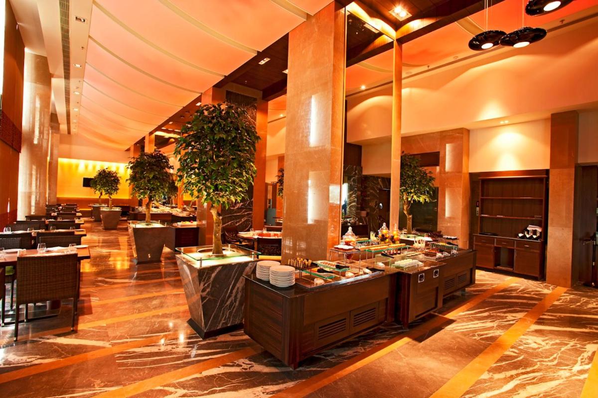 a restaurant with a buffet line in a building at Radisson Blu Hotel Chennai City Centre in Chennai a restaurant with a buffet line in a building at Radisson Blu Hotel Chennai City Centre in Chennai
