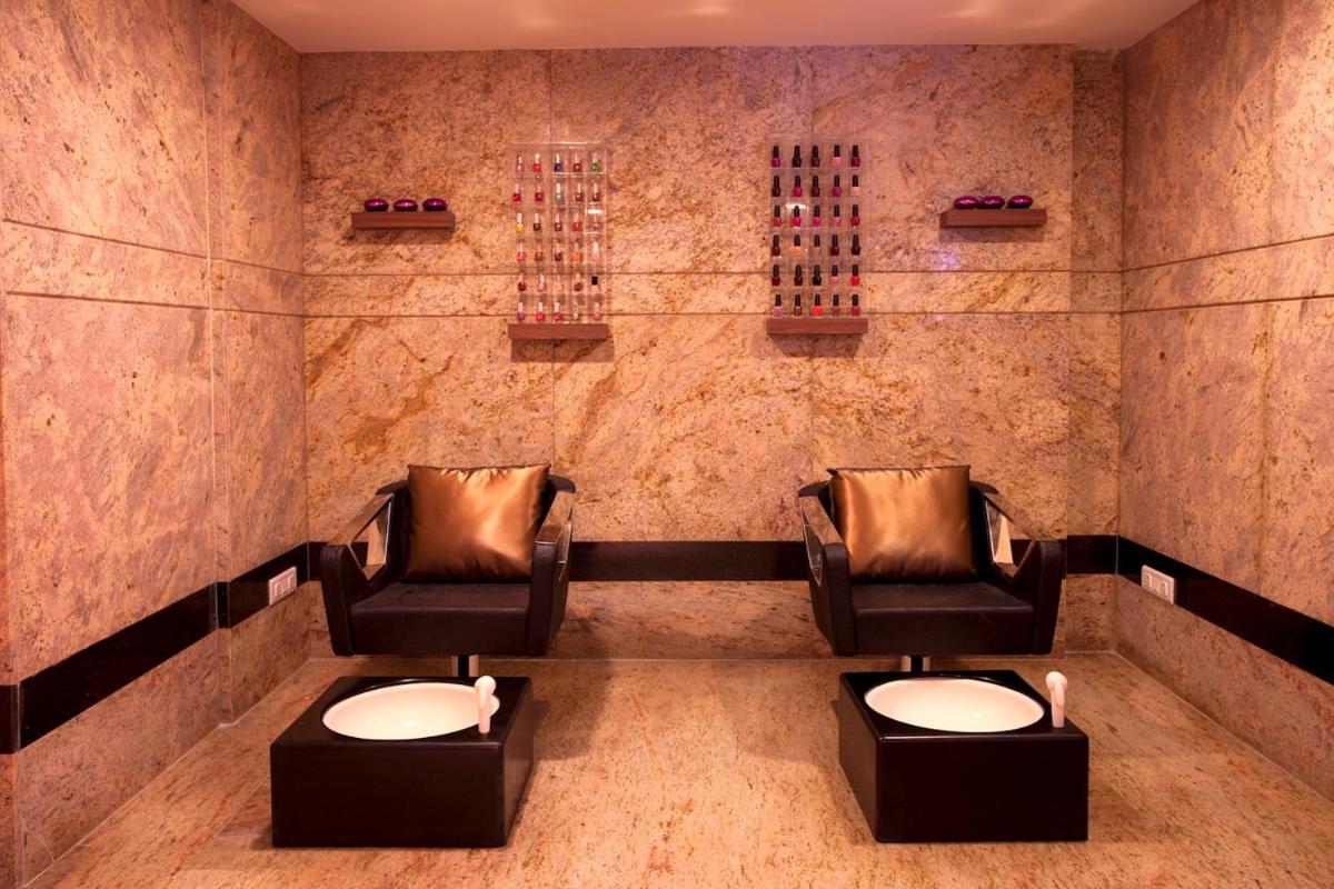 two chairs in a waiting room with wine bottles at Radisson Blu Hotel Chennai City Centre in Chennai two chairs in a waiting room with wine bottles at Radisson Blu Hotel Chennai City Centre in Chennai