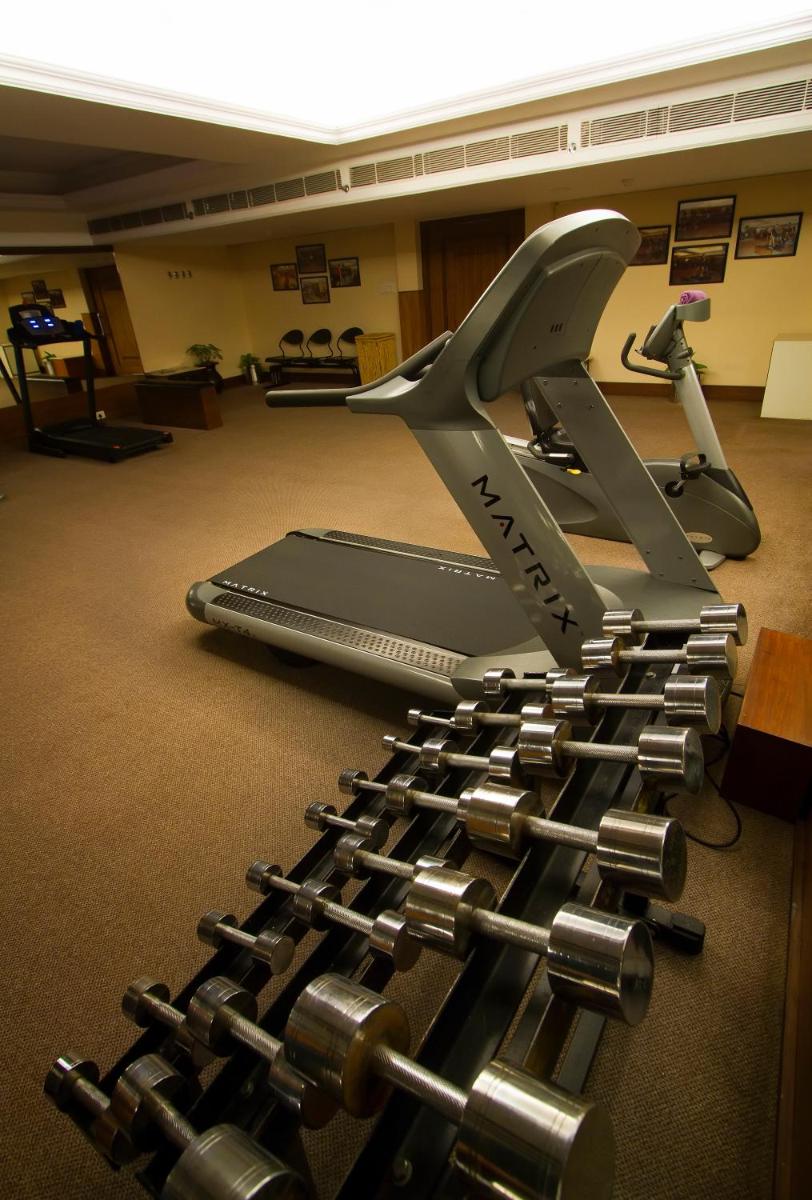 a gym with a pile of dumbbells on the floor at The Piccadily in Lucknow