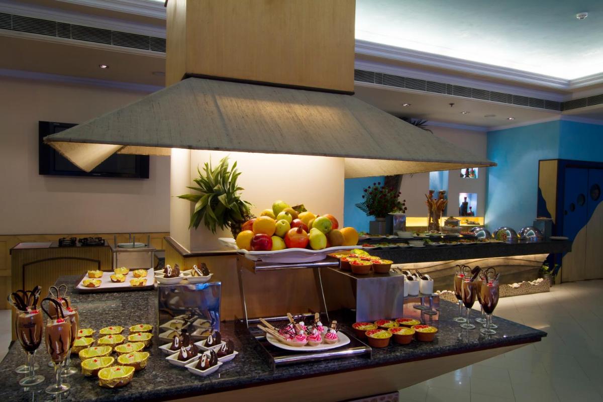 a kitchen with a buffet of food on a counter at The Piccadily in Lucknow