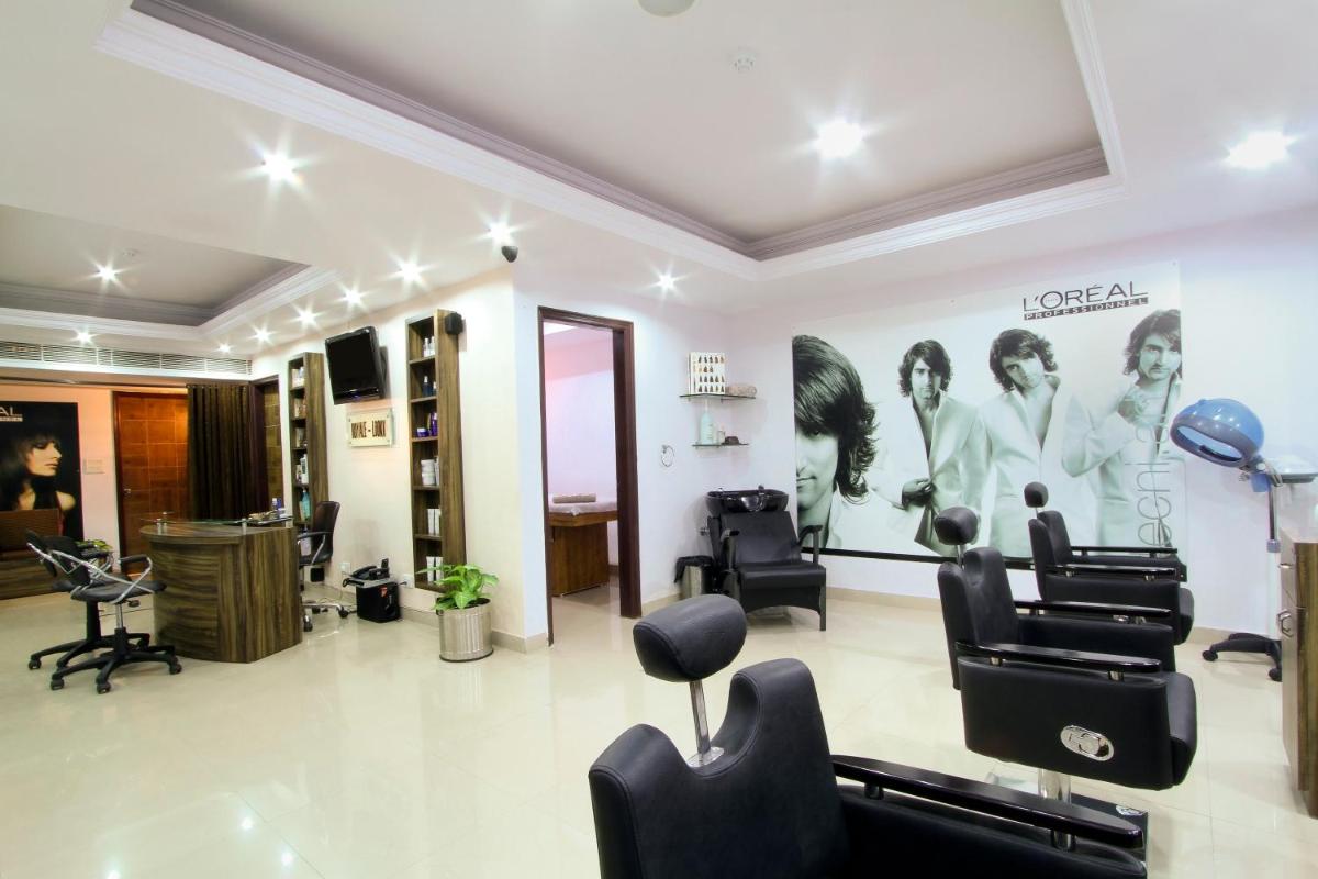 a hair salon with black chairs and a poster on the wall at The Piccadily in Lucknow