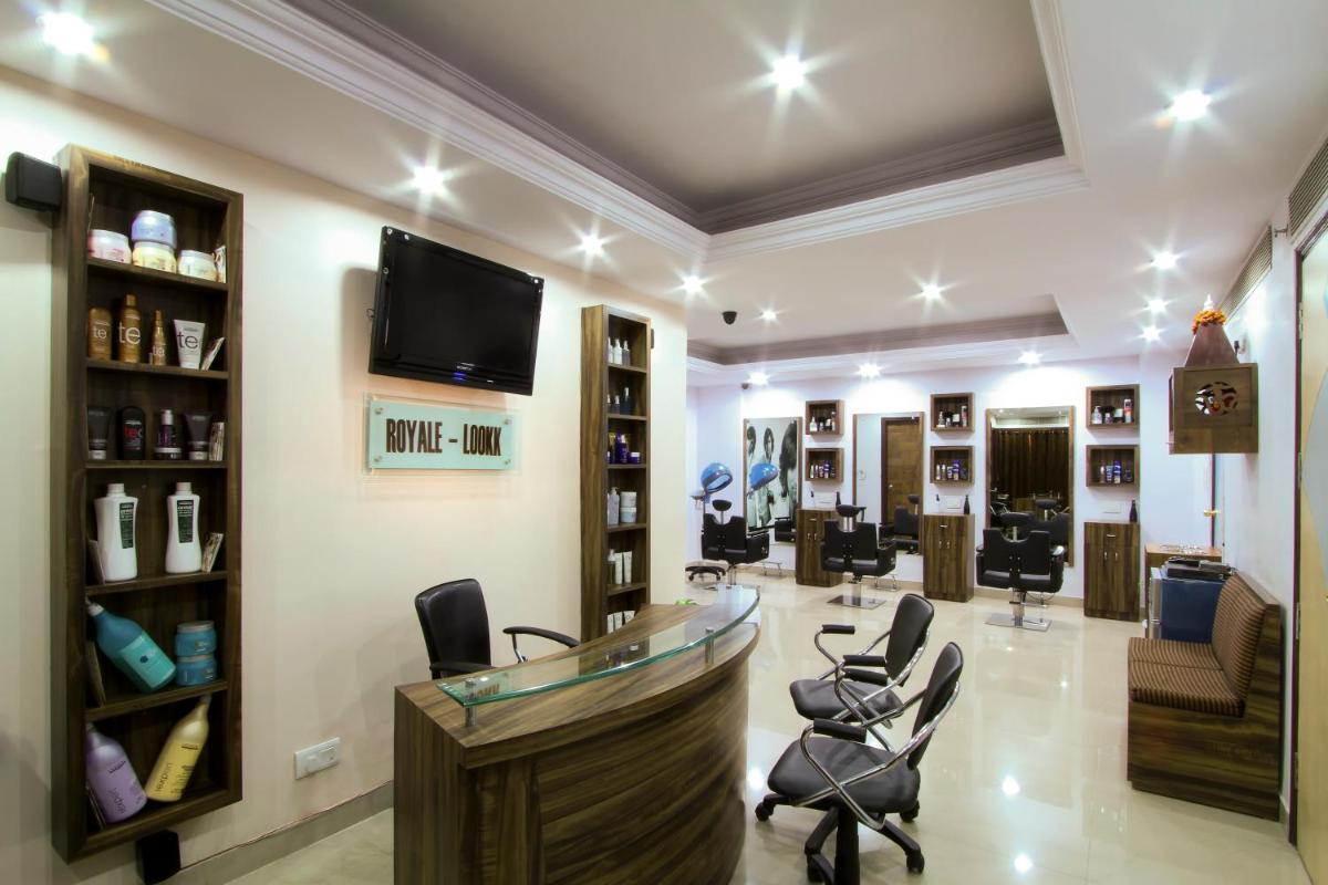 a hair salon with chairs and a tv on the wall at The Piccadily in Lucknow