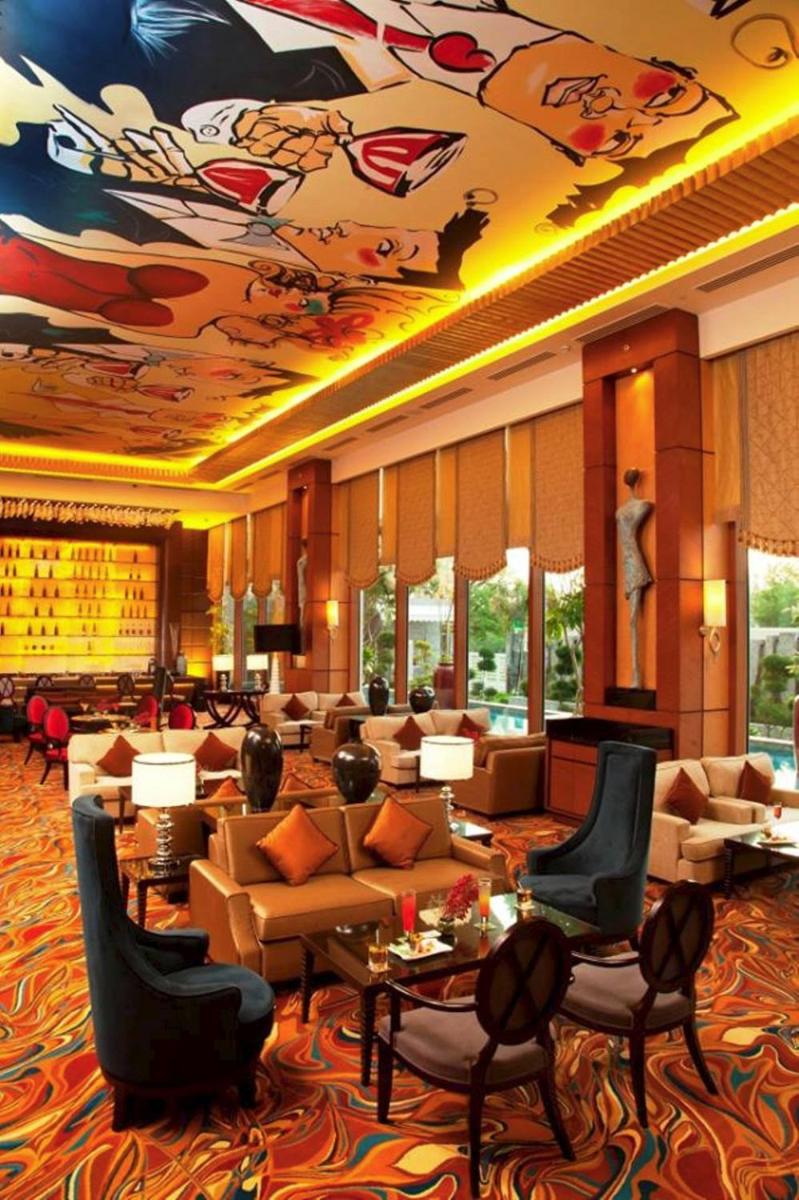 a hotel lobby with couches and tables and a mural at Radisson Blu Hotel, Nagpur in Nagpur