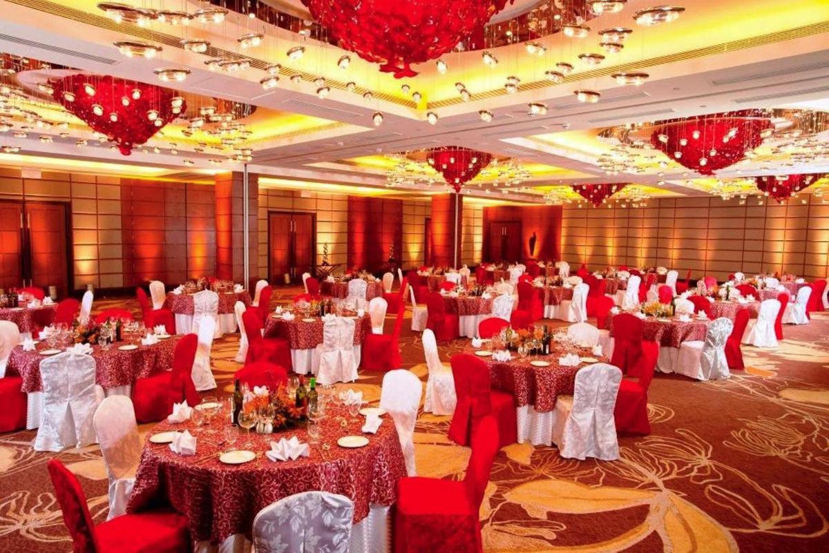 a banquet hall with red and white tables and chairs at Radisson Blu Hotel, Nagpur in Nagpur