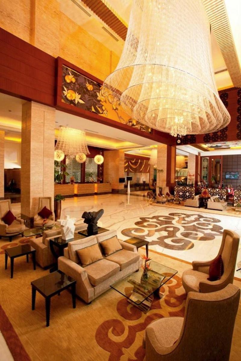 a large lobby with couches and a large chandelier at Radisson Blu Hotel, Nagpur in Nagpur