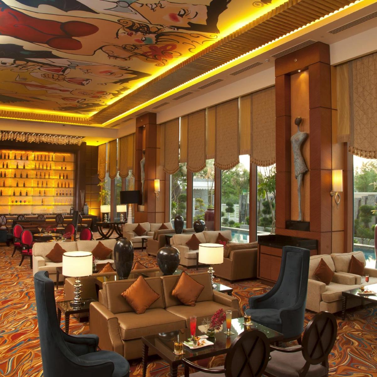 a hotel lobby with couches and tables and chairs at Radisson Blu Hotel, Nagpur in Nagpur
