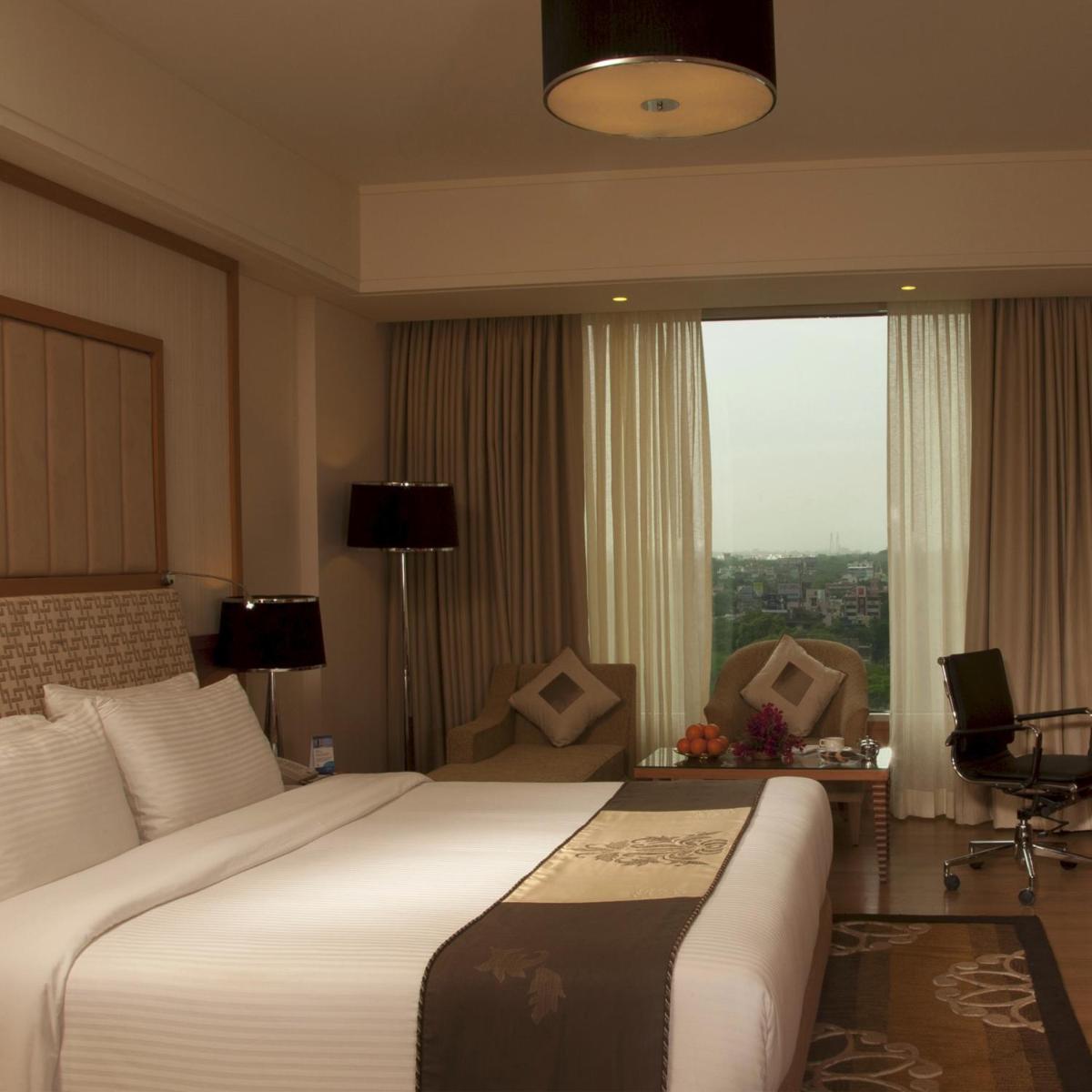 a hotel room with a large bed and a window at Radisson Blu Hotel, Nagpur in Nagpur