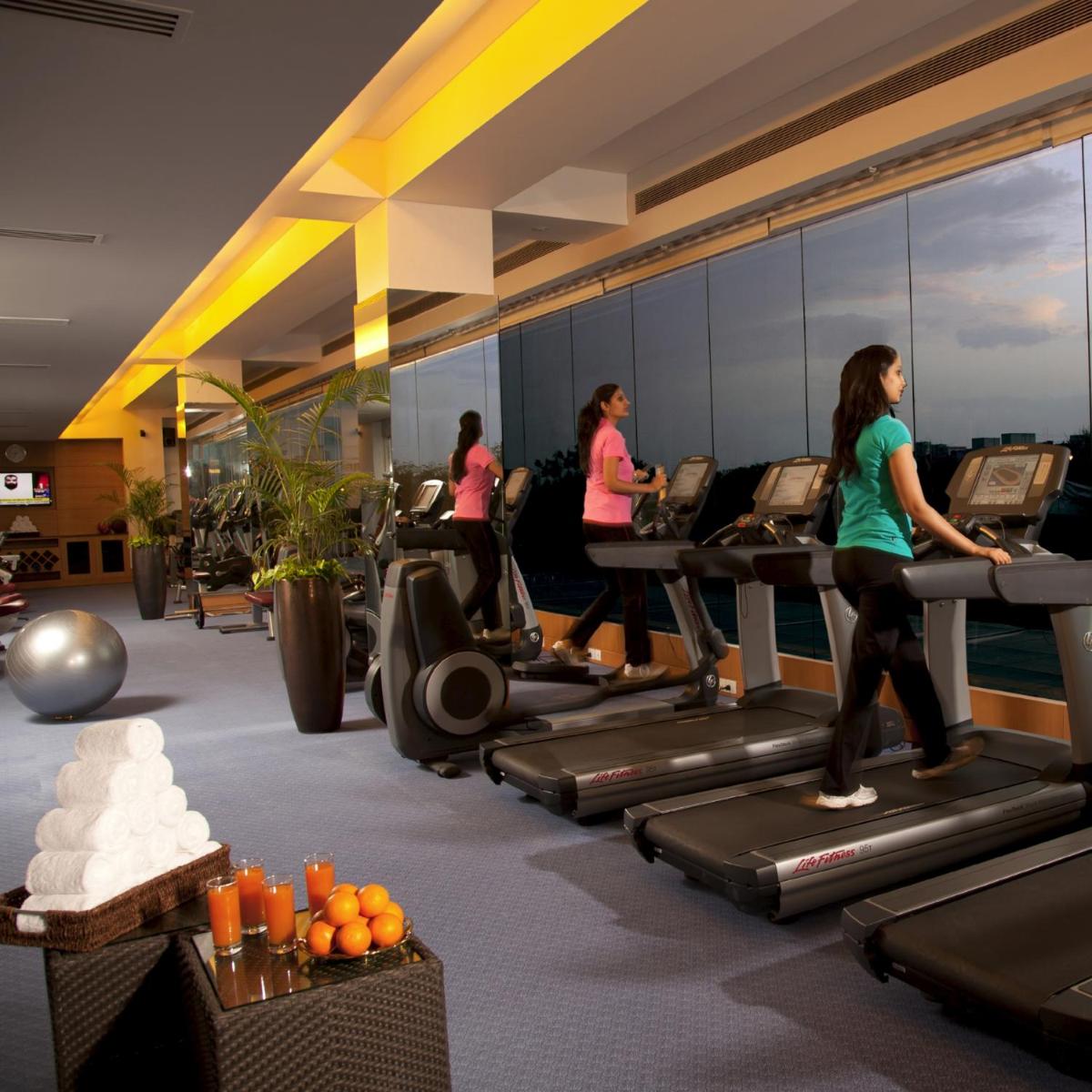a group of people running on treadmills in a gym at Radisson Blu Hotel, Nagpur in Nagpur