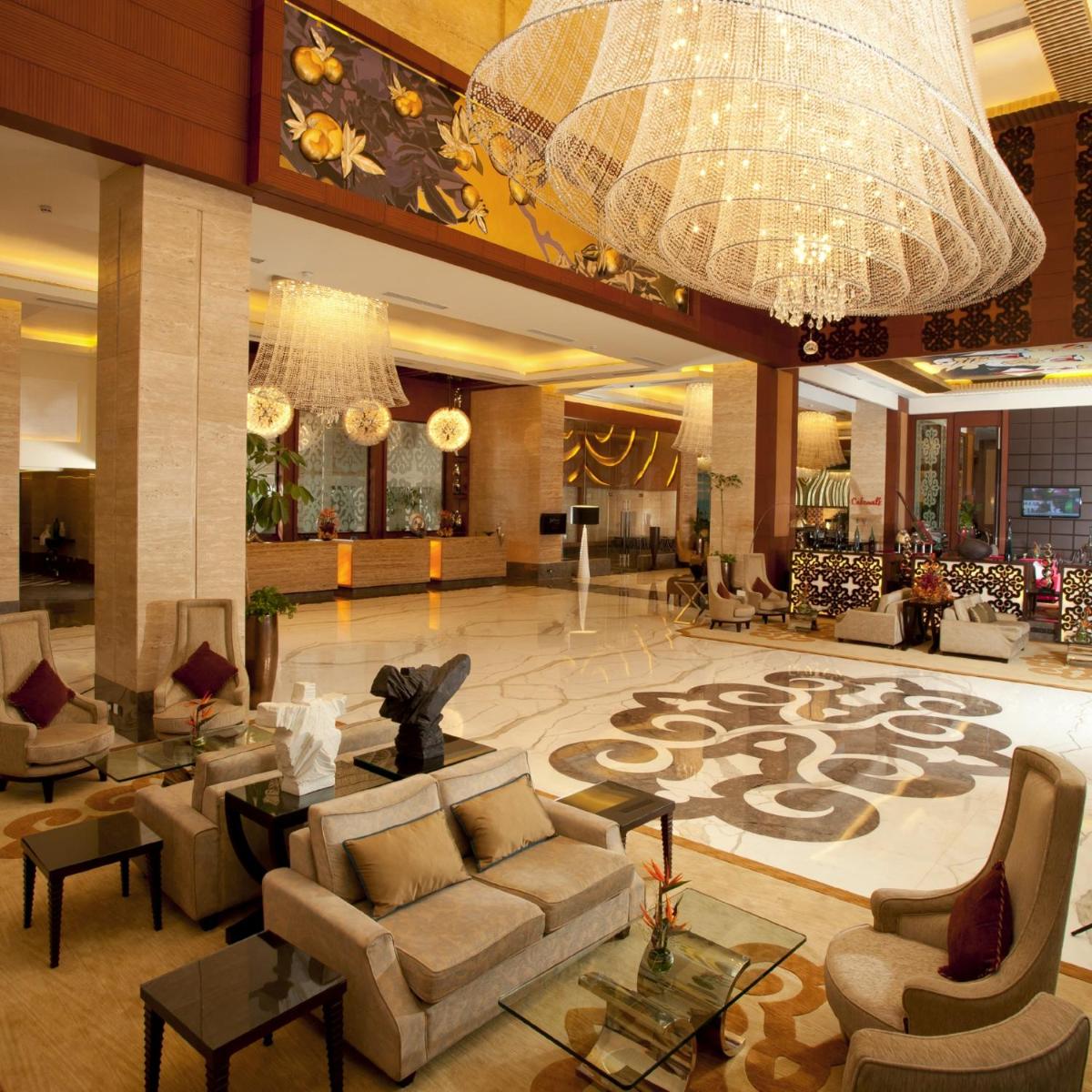 a lobby with couches and a large chandelier at Radisson Blu Hotel, Nagpur in Nagpur