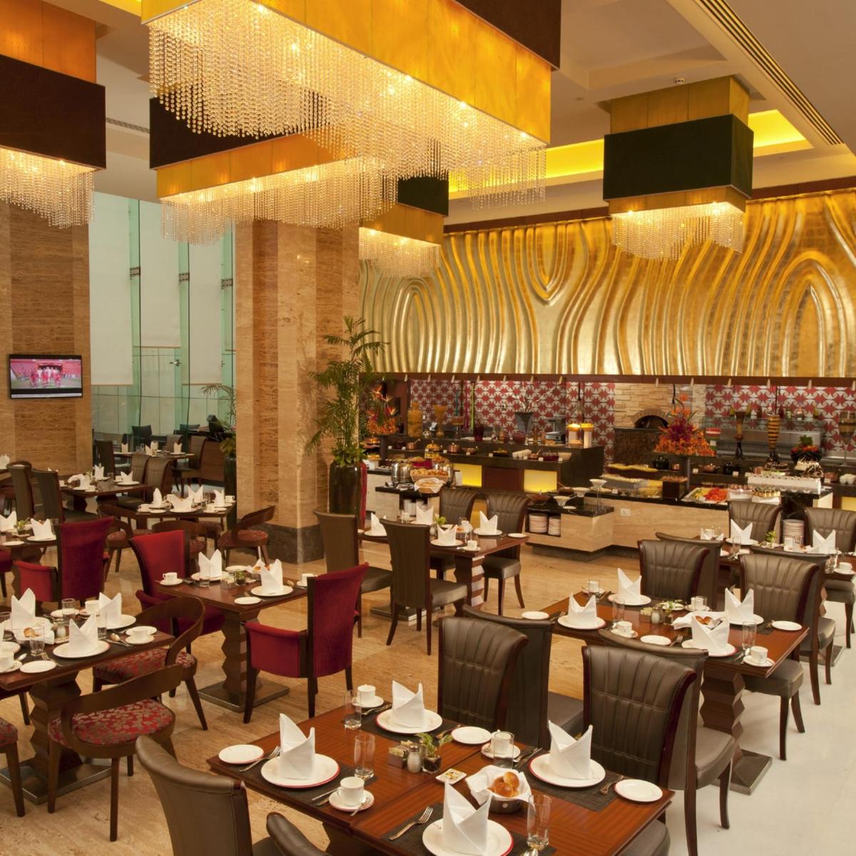 a dining room with tables and chairs and a restaurant at Radisson Blu Hotel, Nagpur in Nagpur