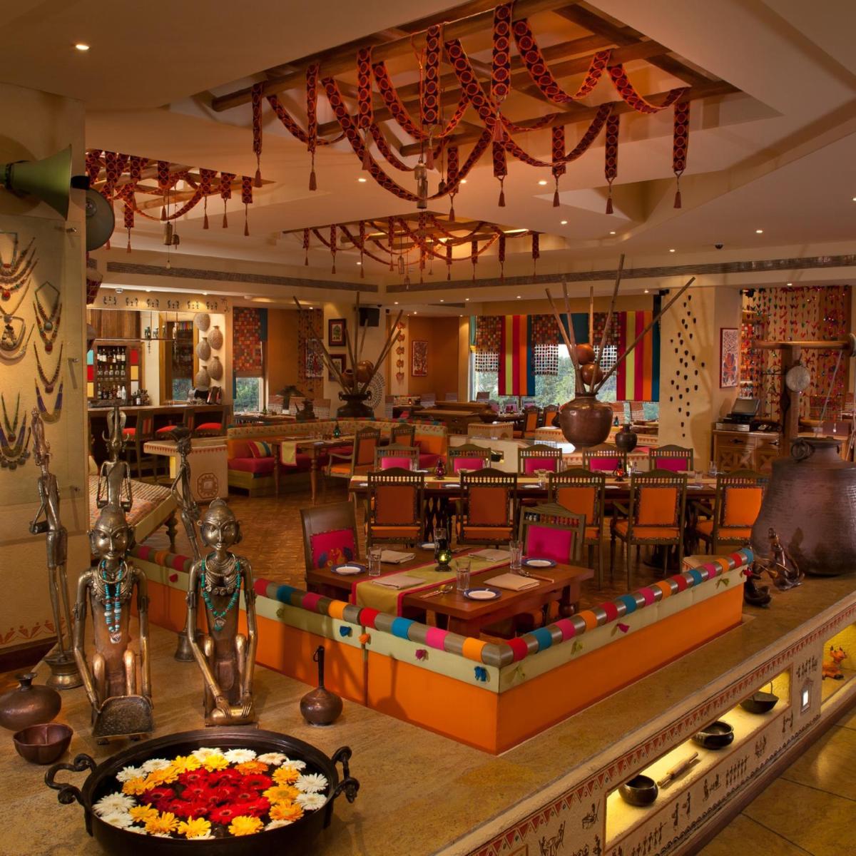 a lobby of a restaurant with a table and chairs at Radisson Blu Hotel, Nagpur in Nagpur