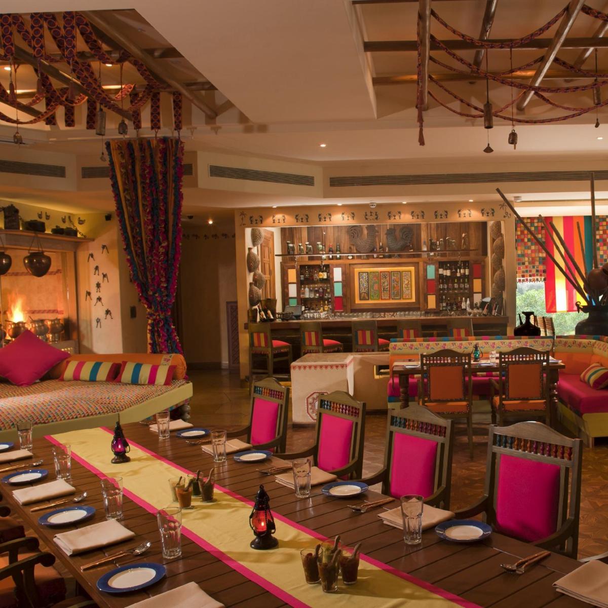 a restaurant with tables and chairs and a bar at Radisson Blu Hotel, Nagpur in Nagpur