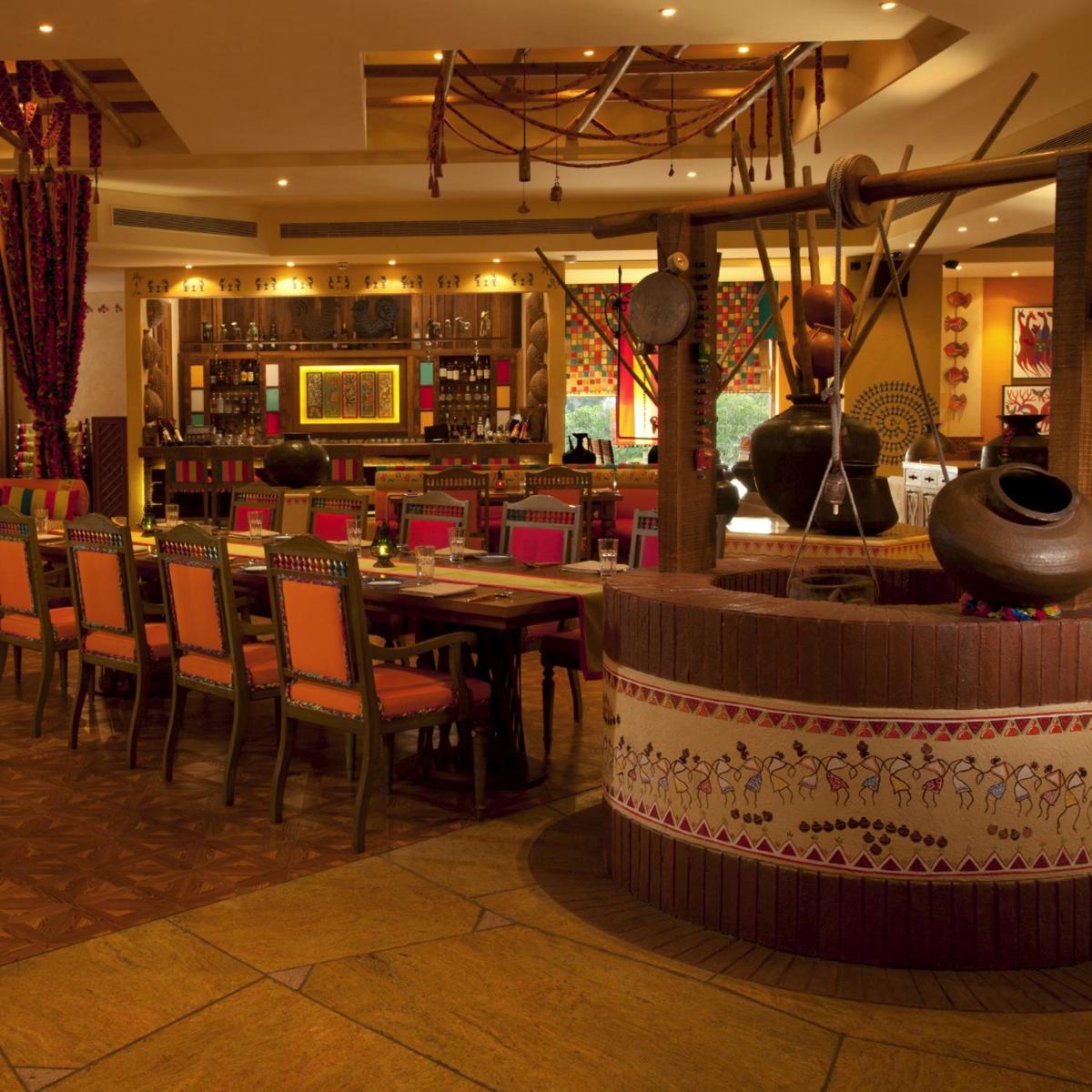 a restaurant with tables and chairs and a bar at Radisson Blu Hotel, Nagpur in Nagpur