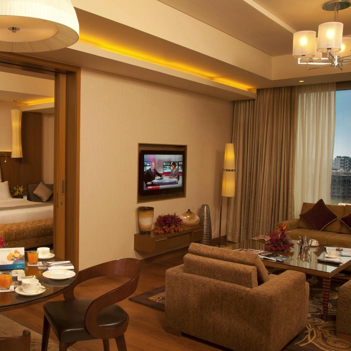 a living room with a couch and a dining room at Radisson Blu Hotel, Nagpur in Nagpur
