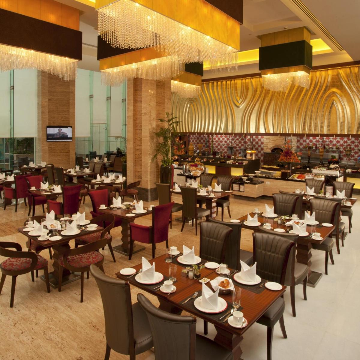 a dining room with tables and chairs and a restaurant at Radisson Blu Hotel, Nagpur in Nagpur
