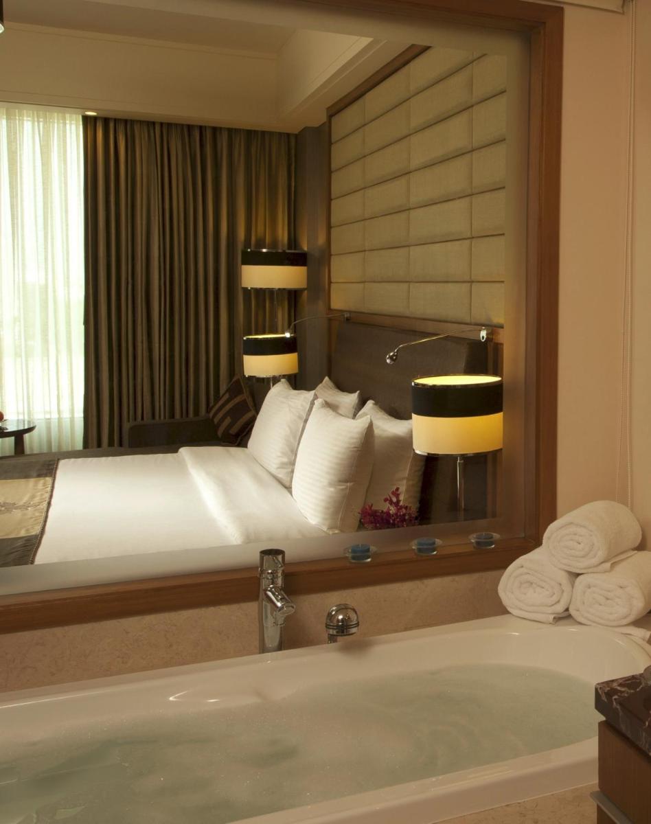 a hotel room with a bed and a bath tub at Radisson Blu Hotel, Nagpur in Nagpur