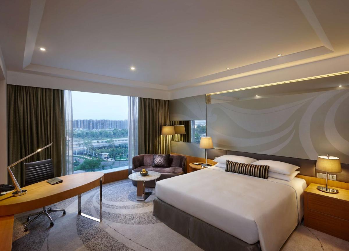 a hotel room with a large bed and a desk at Hyatt Regency Gurgaon in Gurgaon a hotel room with a large bed and a desk at Hyatt Regency Gurgaon in Gurgaon