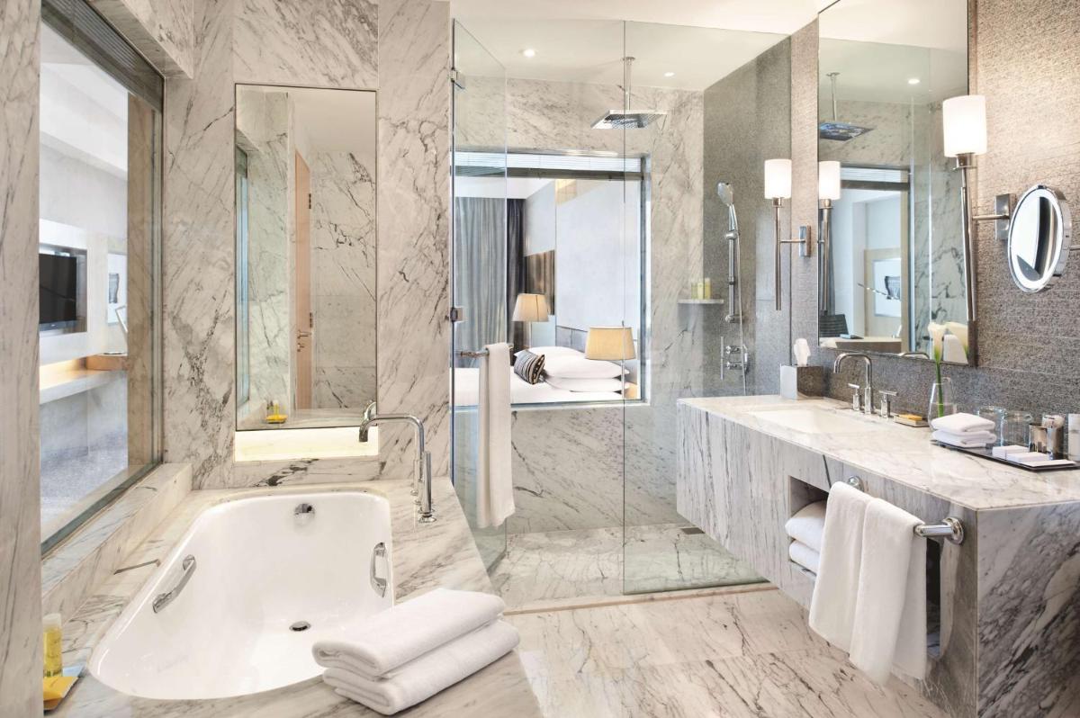 a bathroom with a tub and a sink and a shower at Hyatt Regency Gurgaon in Gurgaon