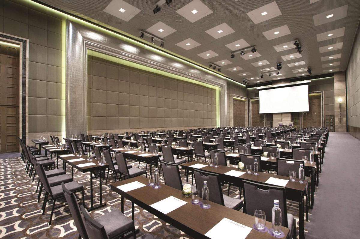 a conference room with tables and chairs and a screen at Hyatt Regency Gurgaon in Gurgaon
