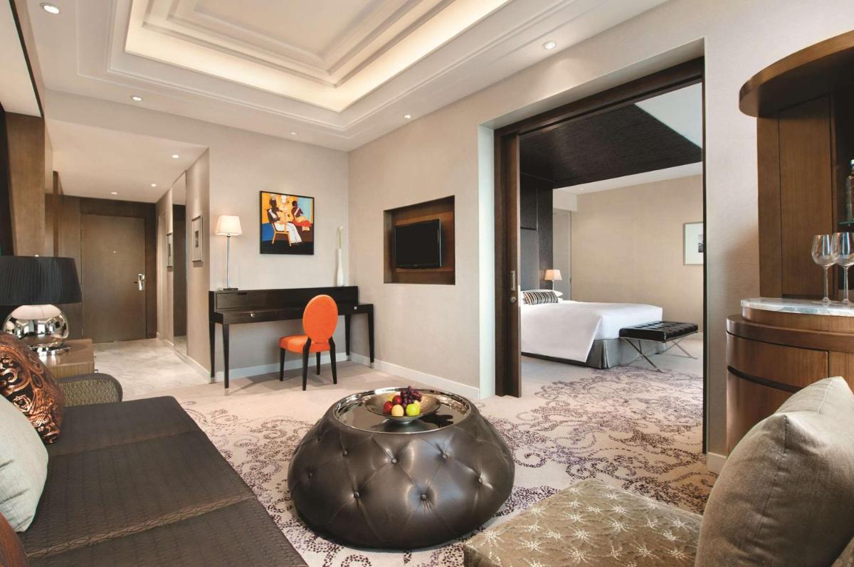a hotel suite with a bed and a living room at Hyatt Regency Gurgaon in Gurgaon