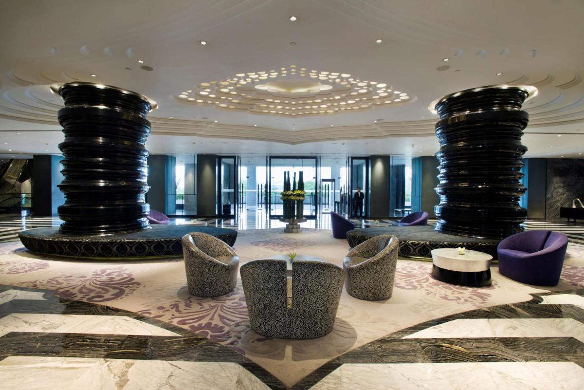 a lobby with chairs and tables in a building at Hyatt Regency Gurgaon in Gurgaon