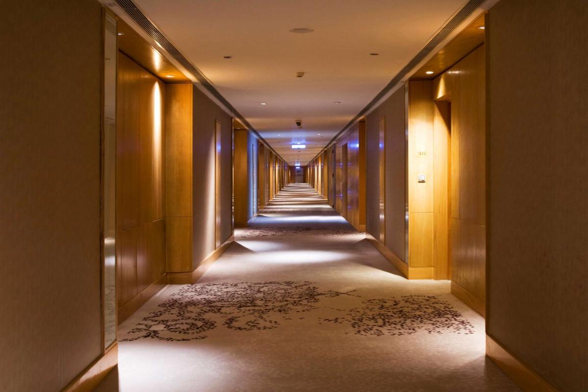 a corridor of a hotel with a long hallway at Hyatt Regency Gurgaon in Gurgaon