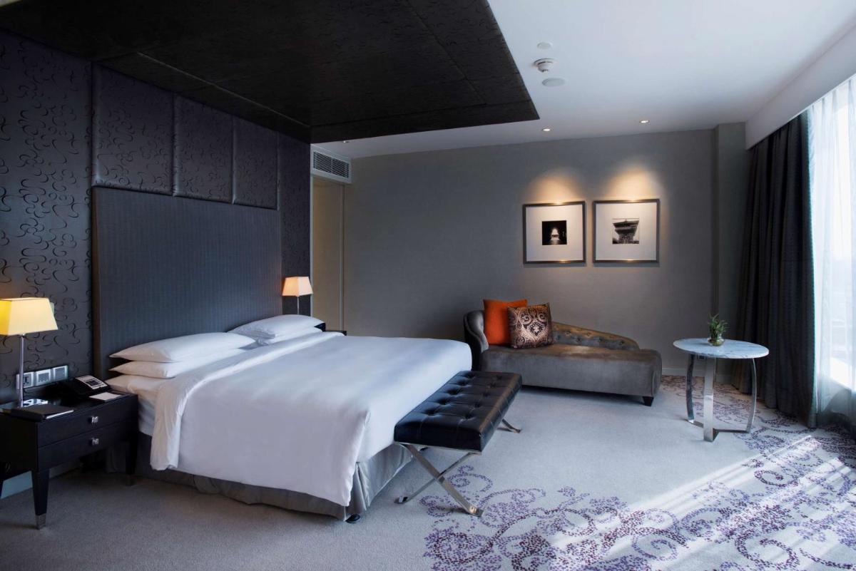 a bedroom with a large bed and a couch at Hyatt Regency Gurgaon in Gurgaon
