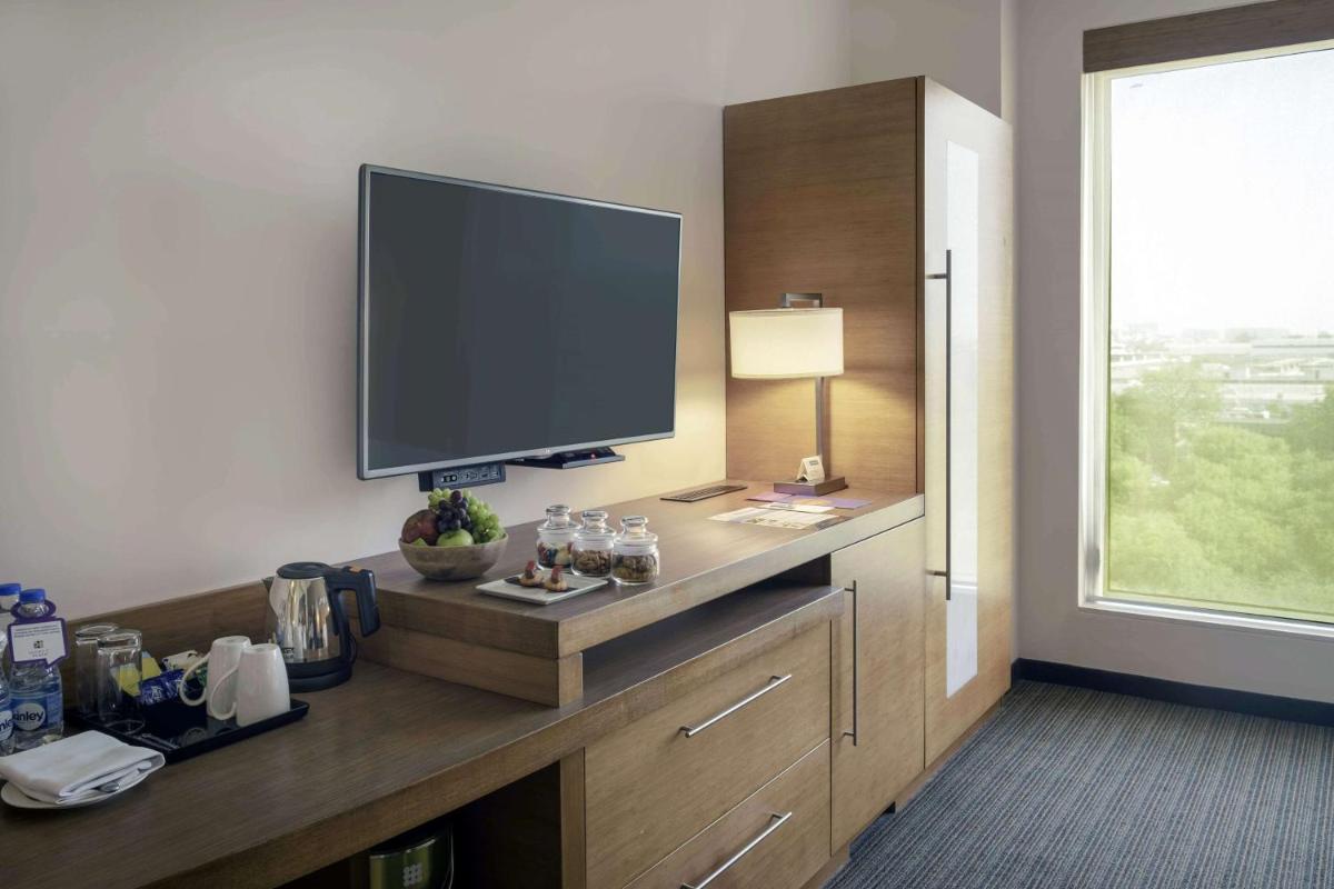a room with a flat screen tv on top of a dresser at Hyatt Place Gurgaon Udyog Vihar in Gurgaon