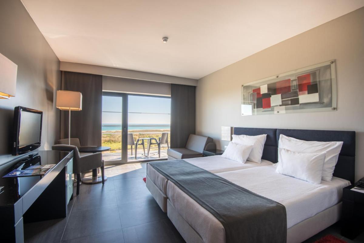 um quarto de hotel com uma cama e vista para o oceano em Vila Gale Lagos em Lagos