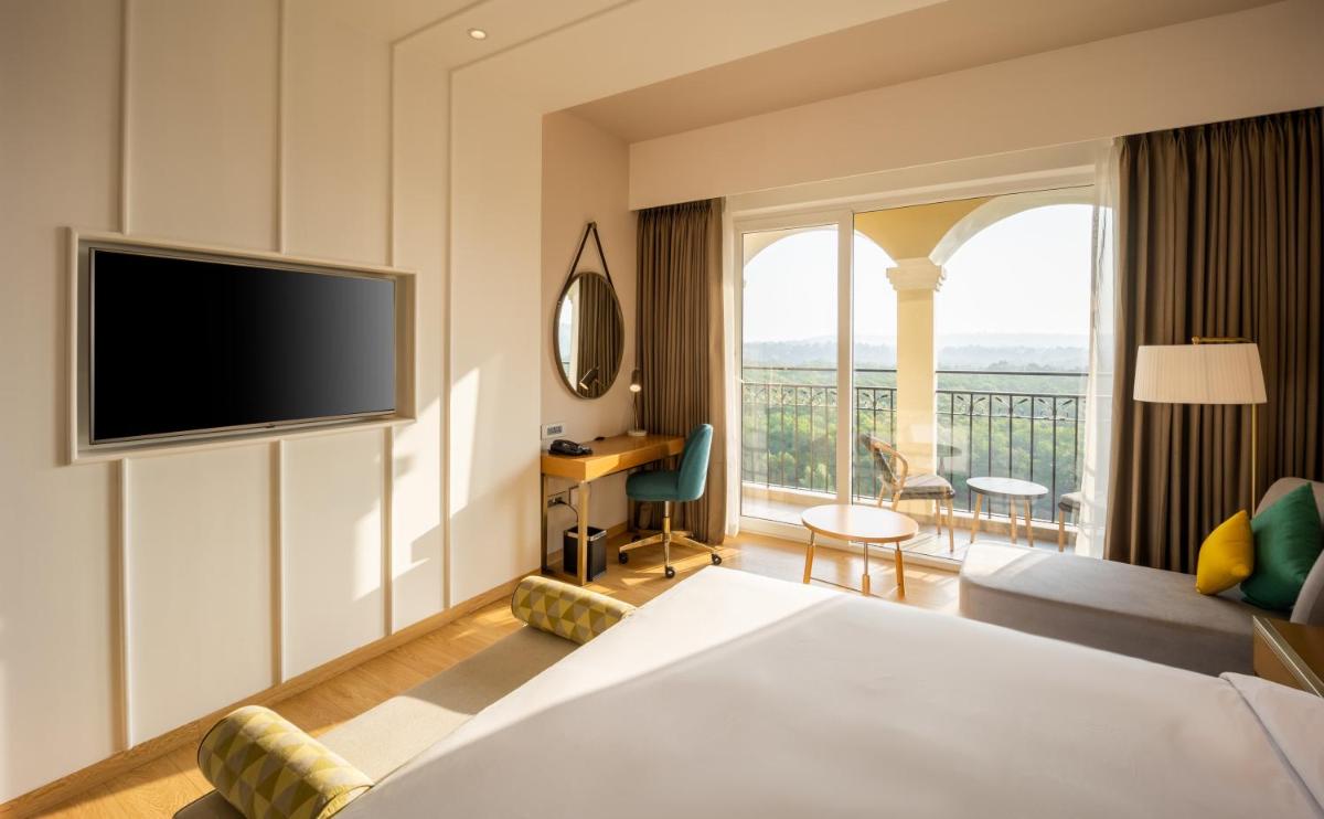 a hotel room with a bed and a television at Holiday Inn Goa Candolim in Candolim a hotel room with a bed and a television at Holiday Inn Goa Candolim in Candolim